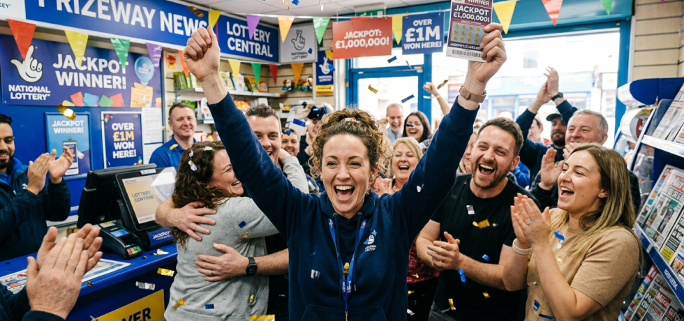 People cheering and clapping inside lottery shop celebrating jackpot winner with ticket and confetti